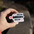 Hand holding a sticker with motivational quote against a blurred natural background